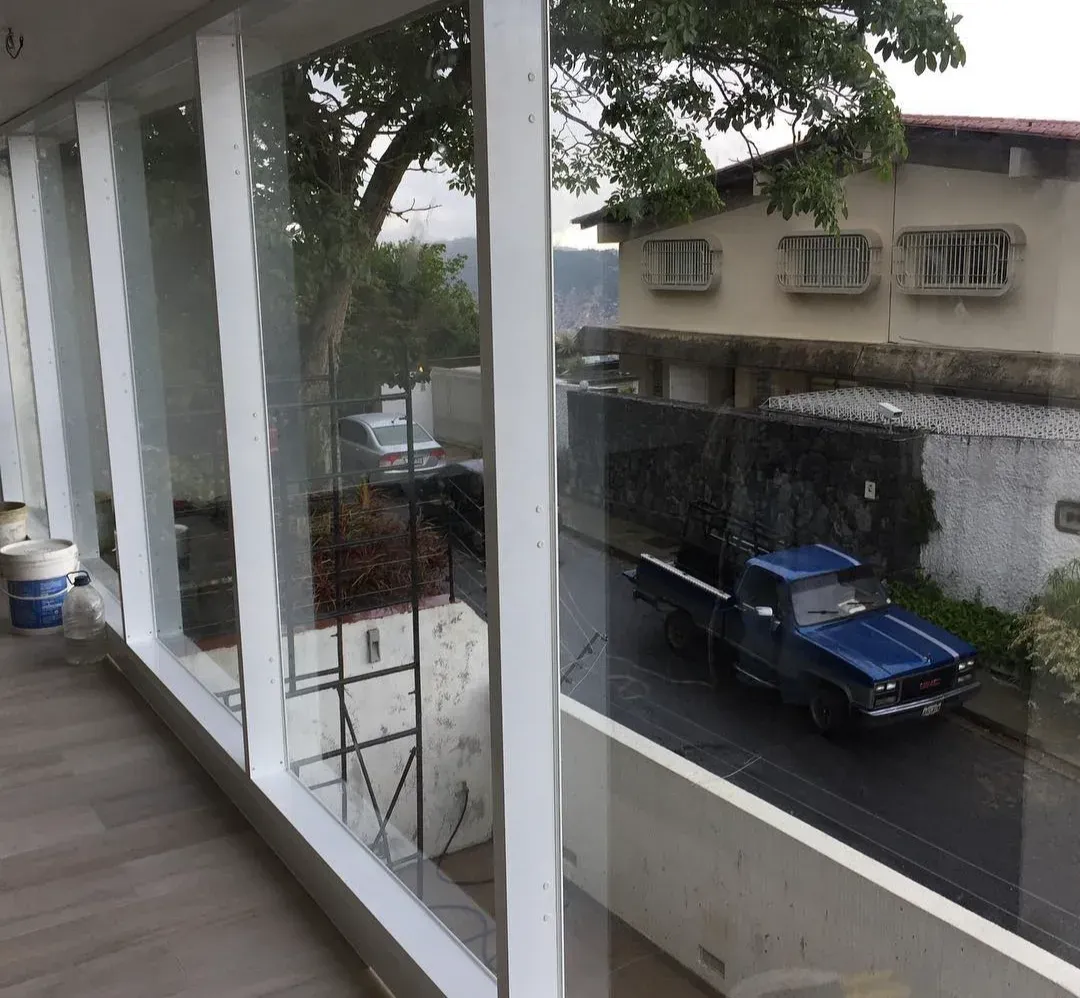 Vista desde el interior de la vivienda hacia la calle, entre las columnas blancas del porche