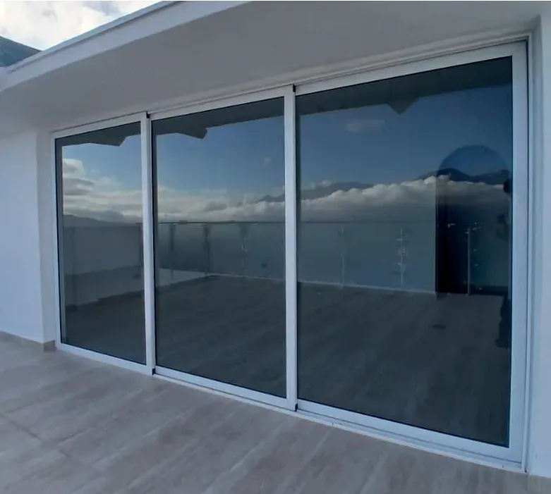 Ventanal corredizo de aluminio que conecta el interior de la vivienda con la terraza